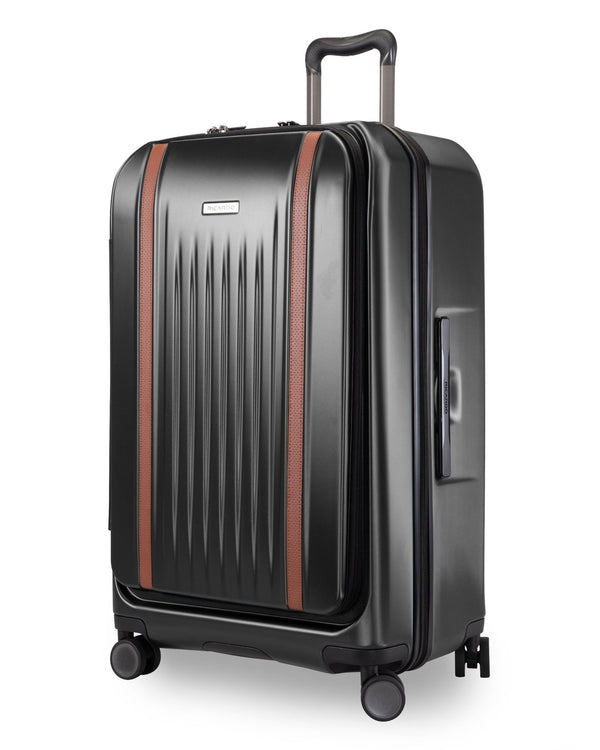 A black hard-shell spinner suitcase with vertical ribbing, brown leather-like trim accents, and an extended telescoping handle, shown on a clean white background.