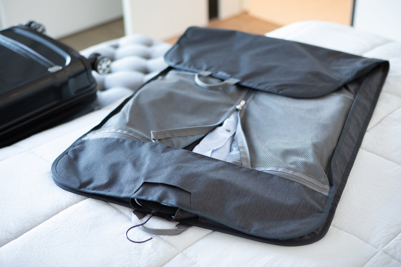 garment carrier laying open on a bed