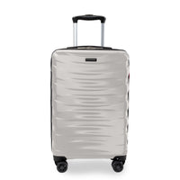 A silver spinner suitcase with a textured wavy pattern, featuring an extended telescopic handle and four multi-directional wheels, shown against a plain white background.
