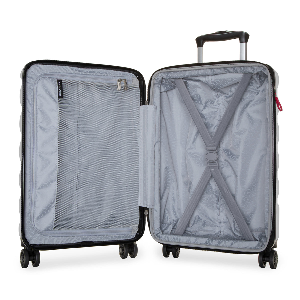 An open hard-shell suitcase shown from the front, displaying its light gray interior lining with a mesh pocket, zipper compartment, and X-strap compression system. The suitcase has a black frame, silver telescoping handle, and four wheels, photographed on a seamless white background.