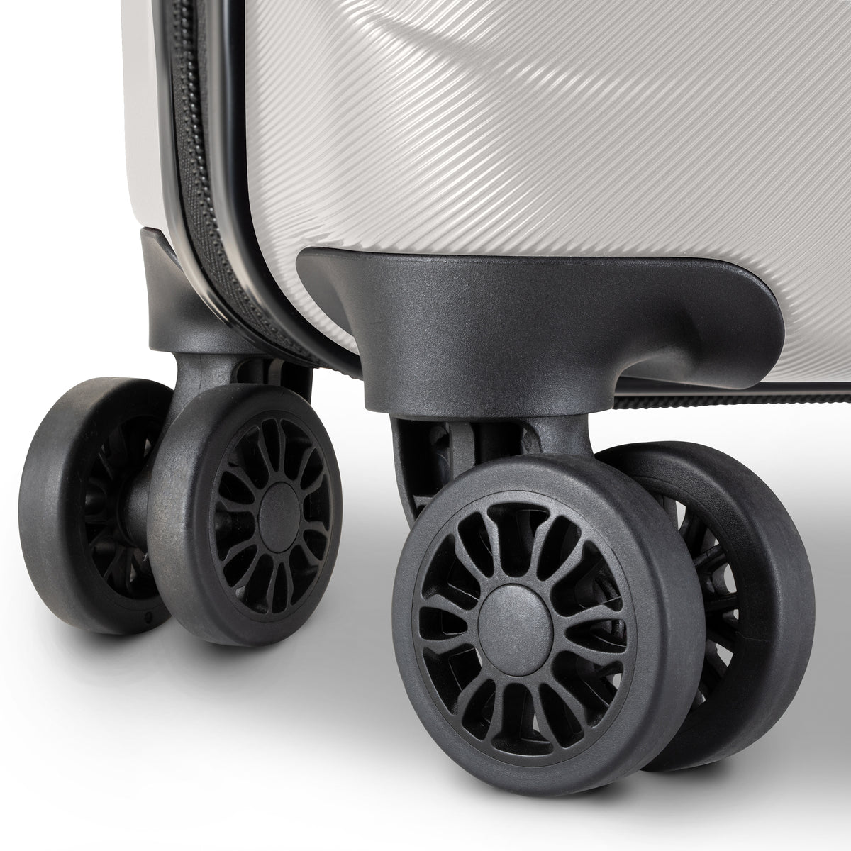 Close-up of a hard-shell suitcase corner showing a textured light gray exterior, black zipper track, and four black spinner wheels on a clean white background.