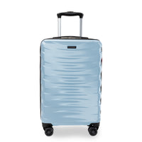 A light blue hardshell spinner suitcase with a textured wavy pattern, featuring a black telescoping handle and four multi-directional wheels, shown on a white background.