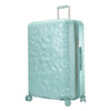 mint green hardside suitcase with a textured surface and metallic accents