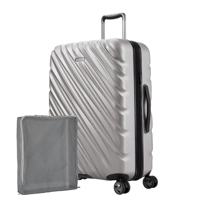 Platinum silver Ricardo Mojave check-in hardside suitcase with diagonal grooves shown with a large grey packing cube