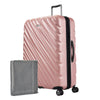Rose gold Ricardo Mojave check-in hardside suitcase with textured diagonal grooves shown with a large grey packing cube
