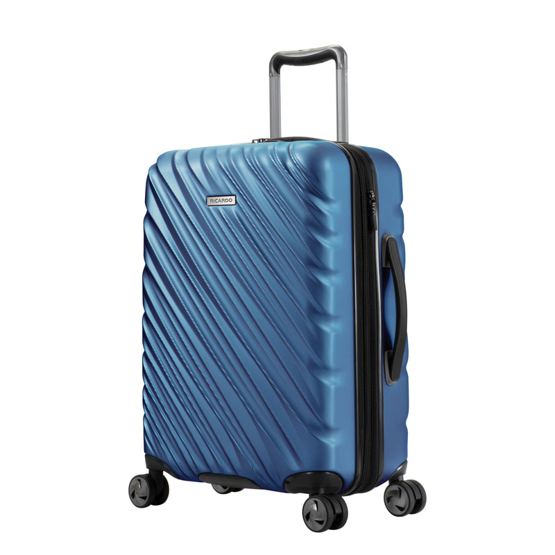 twilight blue Ricardo Mojave carry-on hardside suitcase with diagonal grooves and black accents on the wheels, zipper, and handles